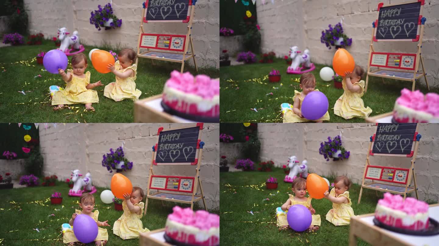 一对双胞胎姐妹在后院一起玩气球庆祝她们的一岁生日