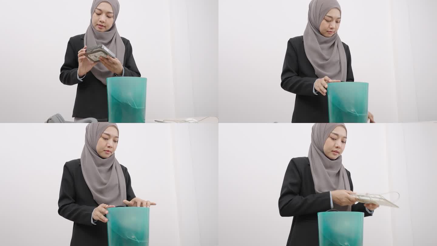 电子废物管理。美丽的亚洲穆斯林妇女把电子垃圾放在纸板箱里，送去回收或妥善处理。环境可持续性。电子垃圾