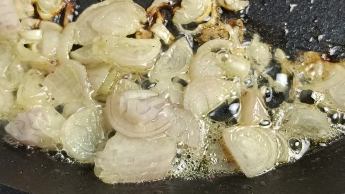 在平底锅里煮切碎的葱