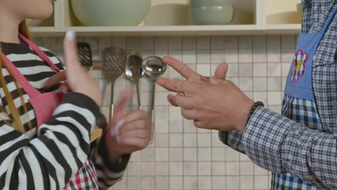 听力受损夫妇在做饭时用手语聊天的特写