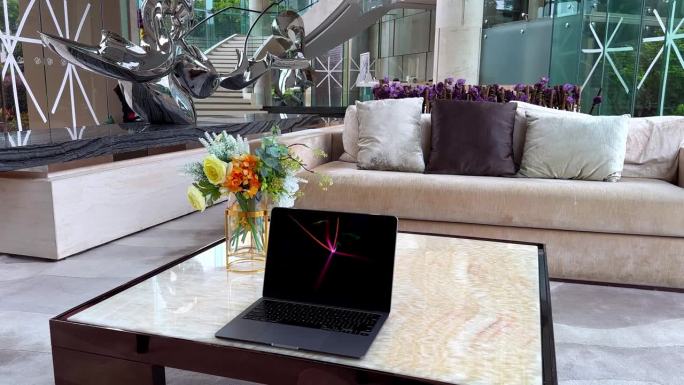 MacBook与屏幕保护程序在大理石桌子在一个豪华的豪宅与胶带窗户