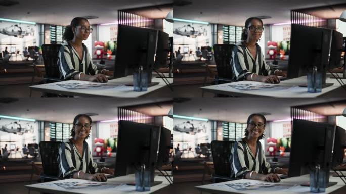 成功的黑人女商人使用台式电脑，分析数据，思考和解决问题的肖像。创意公司现代办公室里微笑着看镜头的女经