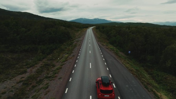 无人驾驶飞机在道路上飞行，揭示车辆行驶在不同的方向在史诗般的北欧风光