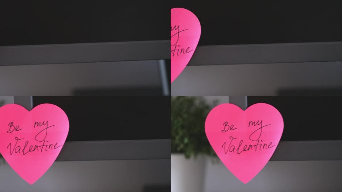 一张粉红色的心形纸条，上面写着“我的情人节”，贴在办公室的显示器上。