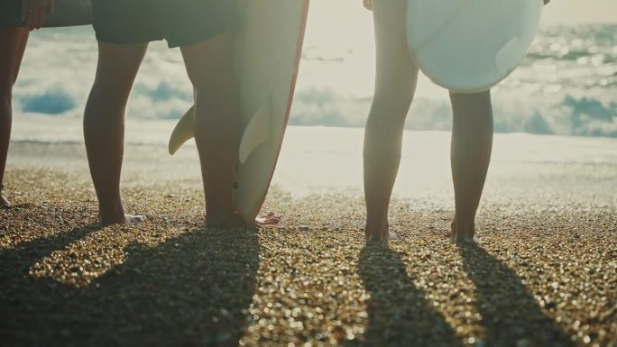 赤脚冲浪的朋友站在阳光明媚的夏日沙滩上