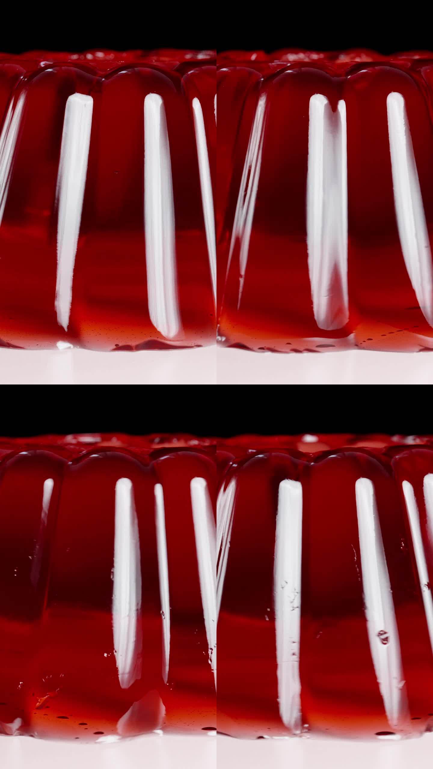 垂直视频。红色果冻在盘子里颤抖，在特写镜头中旋转。
