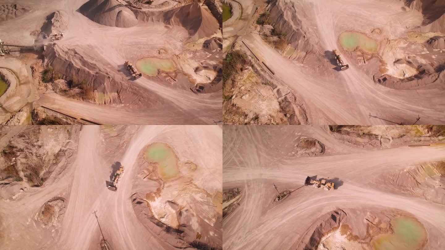无人机拍摄的推土机在一个阳光明媚的日子里在一个大沙矿里工作