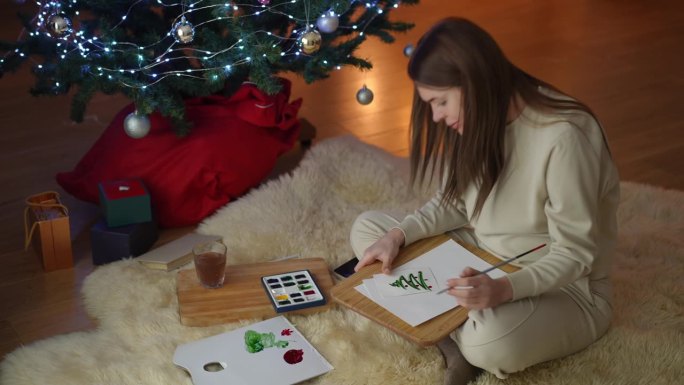一位孕妇在贺卡上画了一棵圣诞树，并对结果很满意。