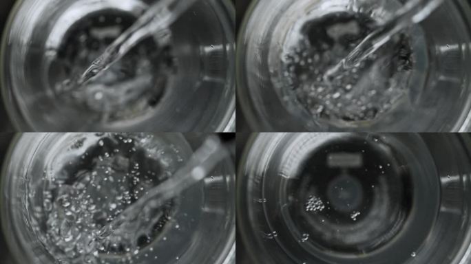 超慢视频:透明液体被倒入双层玻璃杯中的俯拍镜头