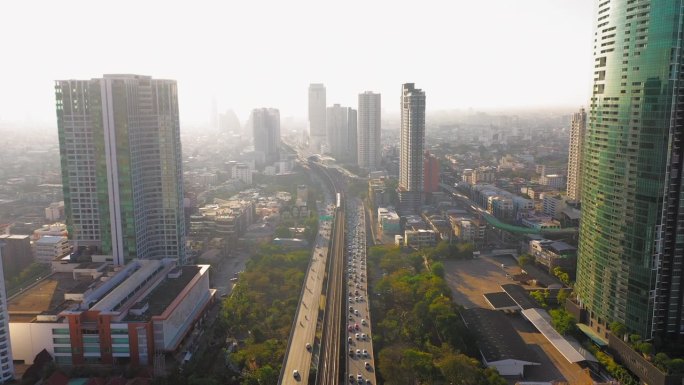 空中无人机拍摄的曼谷湄南河上高速公路和地铁轻轨上的交通信号灯日出场景