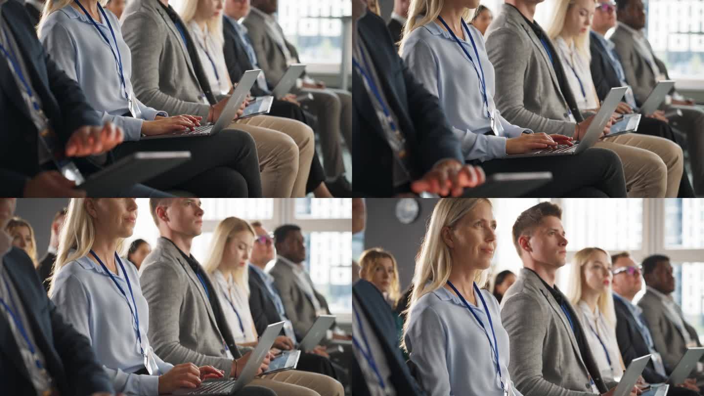 特写:在一场科技会议上，女性高级经理坐在黑暗拥挤的礼堂里。白人妇女使用笔记本电脑。专业观看软件及高科
