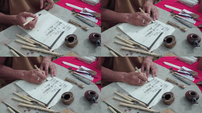 一个人用古罗马工具在羊皮纸上写字的手