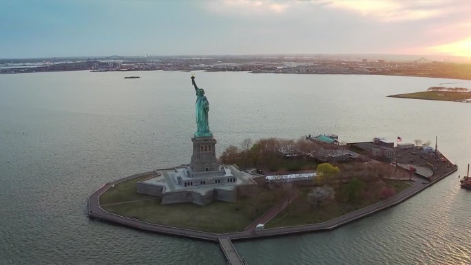 日落时的自由女神像鸟瞰图。背景是曼哈顿和新泽西的天际线。纽约，美国。从直升机上拍摄的。