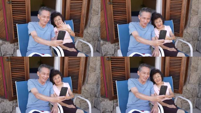 老年旅行者夫妇在酒店阳台上用手机进行视频通话