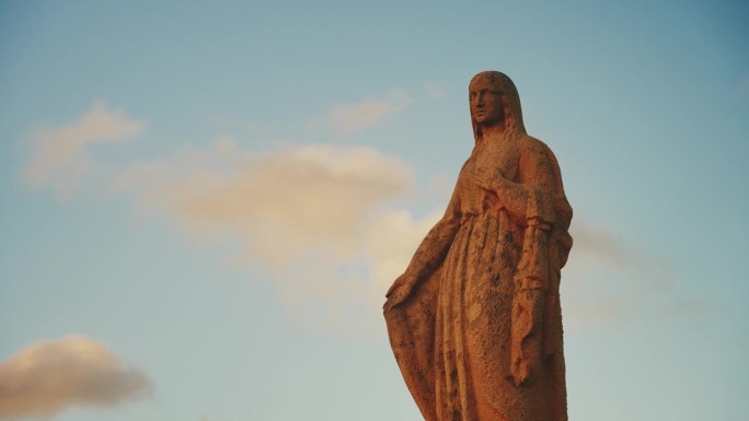 低角度观看圣母玛利亚雕像对着蓝天