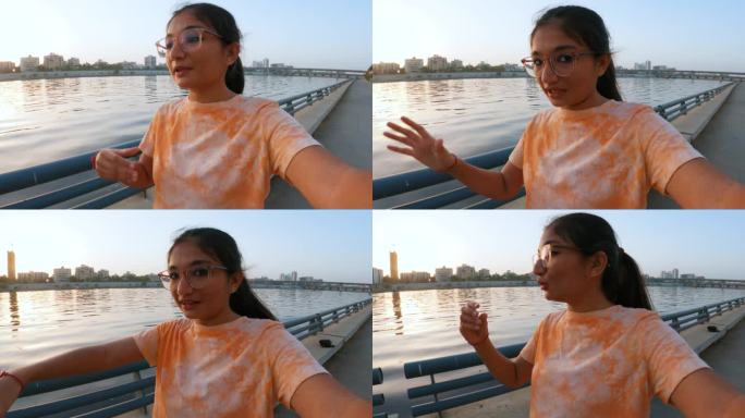 印度少女在印度古吉拉特邦艾哈迈达巴德萨巴尔马蒂河边自拍的视频。旅游影响者探索城市并为社交媒体制作视频