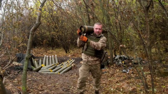 一名男性军事操作员准备在茂密的森林中发射炮弹。军事防御和军事装备的概念。