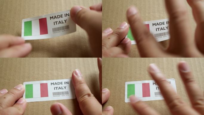 手应用制造在意大利国旗标签上的运输箱与产品优质条码。制造和交付。产品出厂进出口。