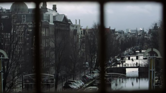冬季透过窗户看到阿姆斯特丹运河的桥梁和古老的历史建筑