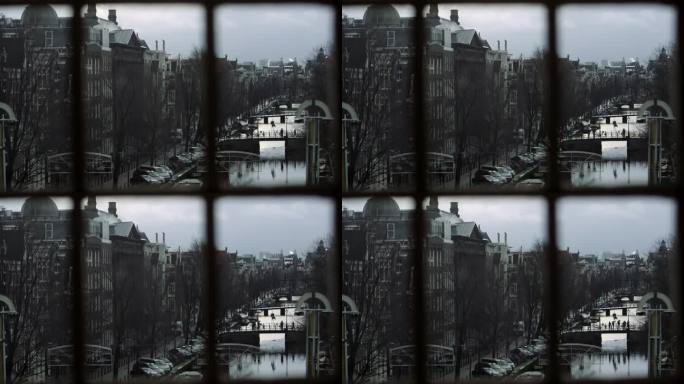 冬季透过窗户看到阿姆斯特丹运河的桥梁和古老的历史建筑