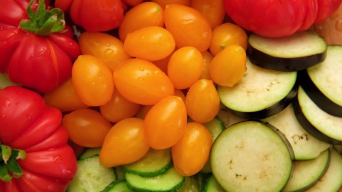 混合新鲜蔬菜背景。健康饮食食材。将蔬菜，西红柿，黄瓜，圣女果，茄子切成薄片。营养，饮食，素食。各种水