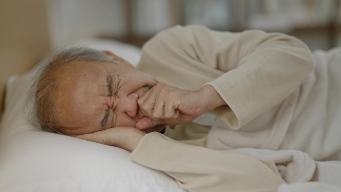 老人睡觉时咳嗽，醒来后喝水。