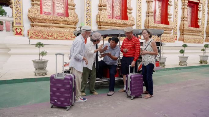 老年亚洲夫妇，老年高加索夫妇，是朋友，拖着大旅行箱一起旅行清迈，与司机议价，包租四人的嘟嘟车。
