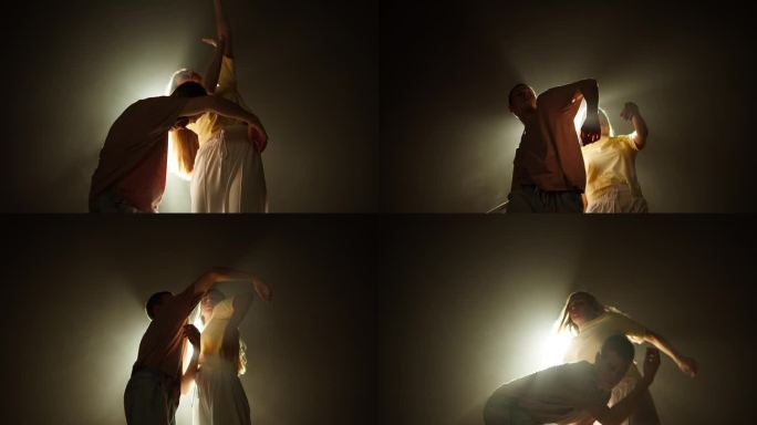 专业的年轻舞蹈编导在工作室里用白光在黑暗的背景上跳现代舞。才华横溢的舞者在舞蹈音乐视频、双人舞、二人