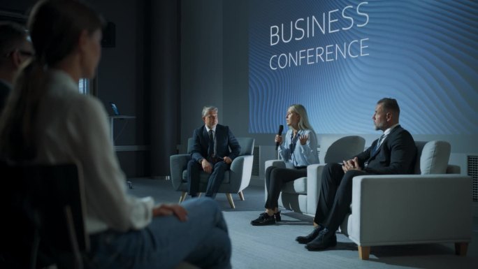 国际商务会议:白人女性科技公司首席执行官在不同的与会者面前与男性主持人交谈。成功女性为女性领袖发表励