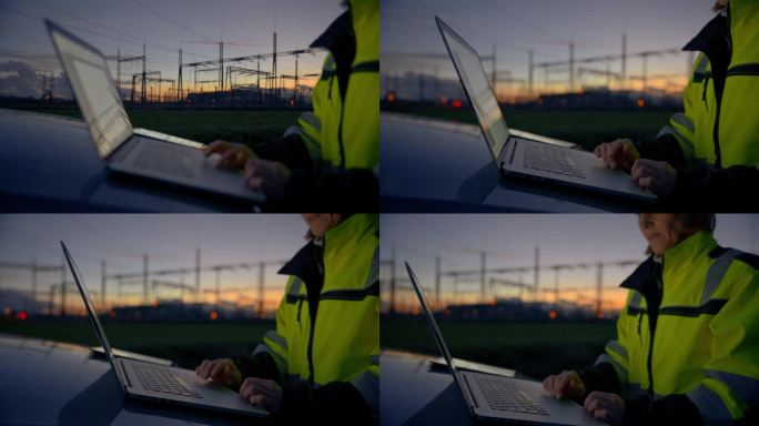 黄昏时分，女电气工程师在汽车引擎盖上使用笔记本电脑