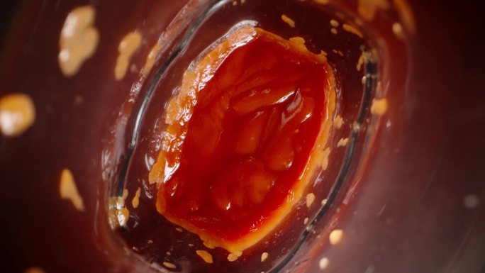 当番茄酱从瓶子里飞出来时，相机一直聚焦在它身上，用微距镜头捕捉到这一刻的细节。
