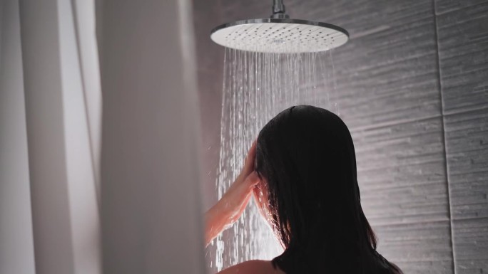 黑发女子在淋浴时抚摸着洗头