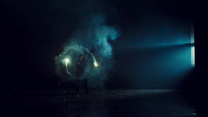 一个神秘的火舞者在黑暗的舞台上旋转火球的肖像。具有烟雾和实用火焰效果的创意艺术表演。穆迪电影超级慢动