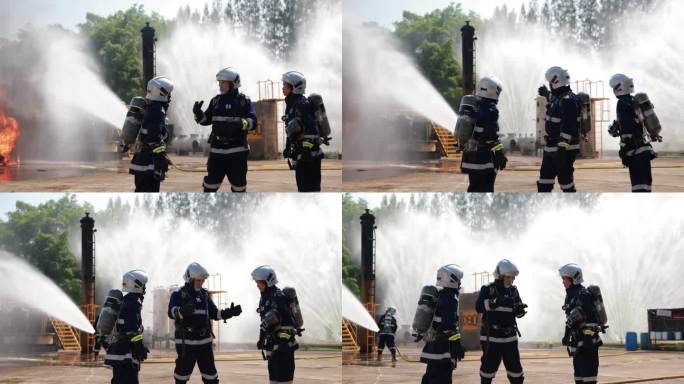 专业消防员使用消防水带灭火。消防队员戴安全帽，穿防护服。灭火器救援训练