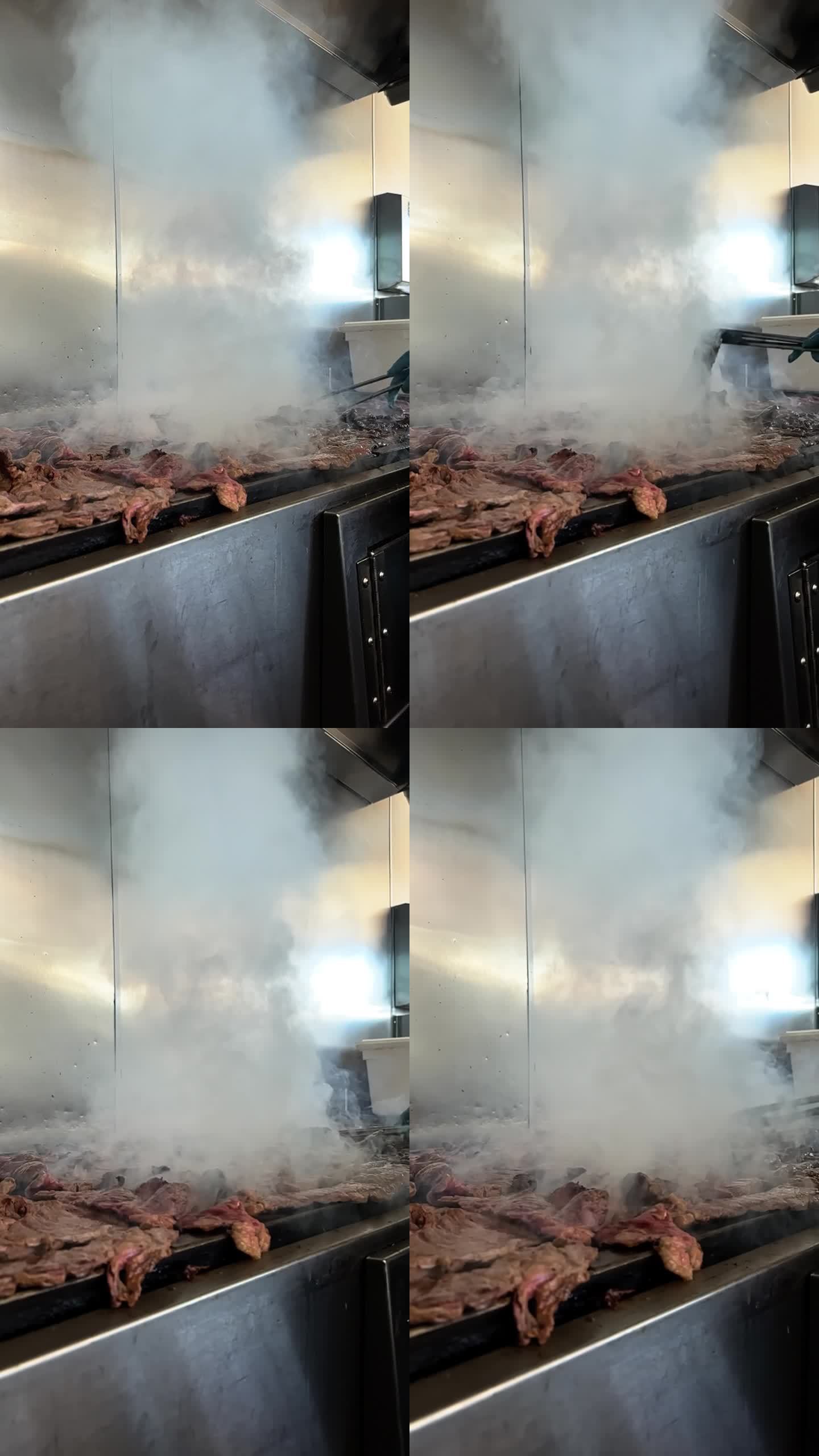 厨师在烤架上翻转浅田牛肉的慢动作垂直镜头
