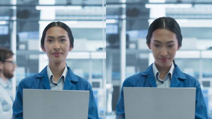 垂直屏幕:电子制造工程师微笑着看着相机。年轻的亚洲女性使用笔记本电脑进行在线研究，监控工业人工智能系