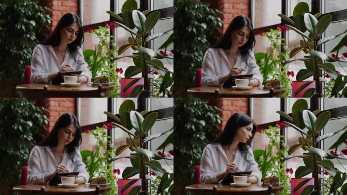年轻的成年女商人在咖啡馆用平板电脑和手写笔工作，成功女性的肖像