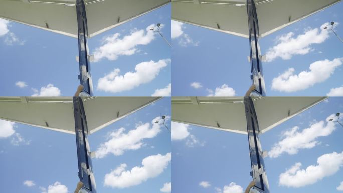 在蓝天中，霍克750飞机尾部对着云的裁剪镜头。垂直尾翼的手动移动舵，以适应尾翼表面产生的力的变化