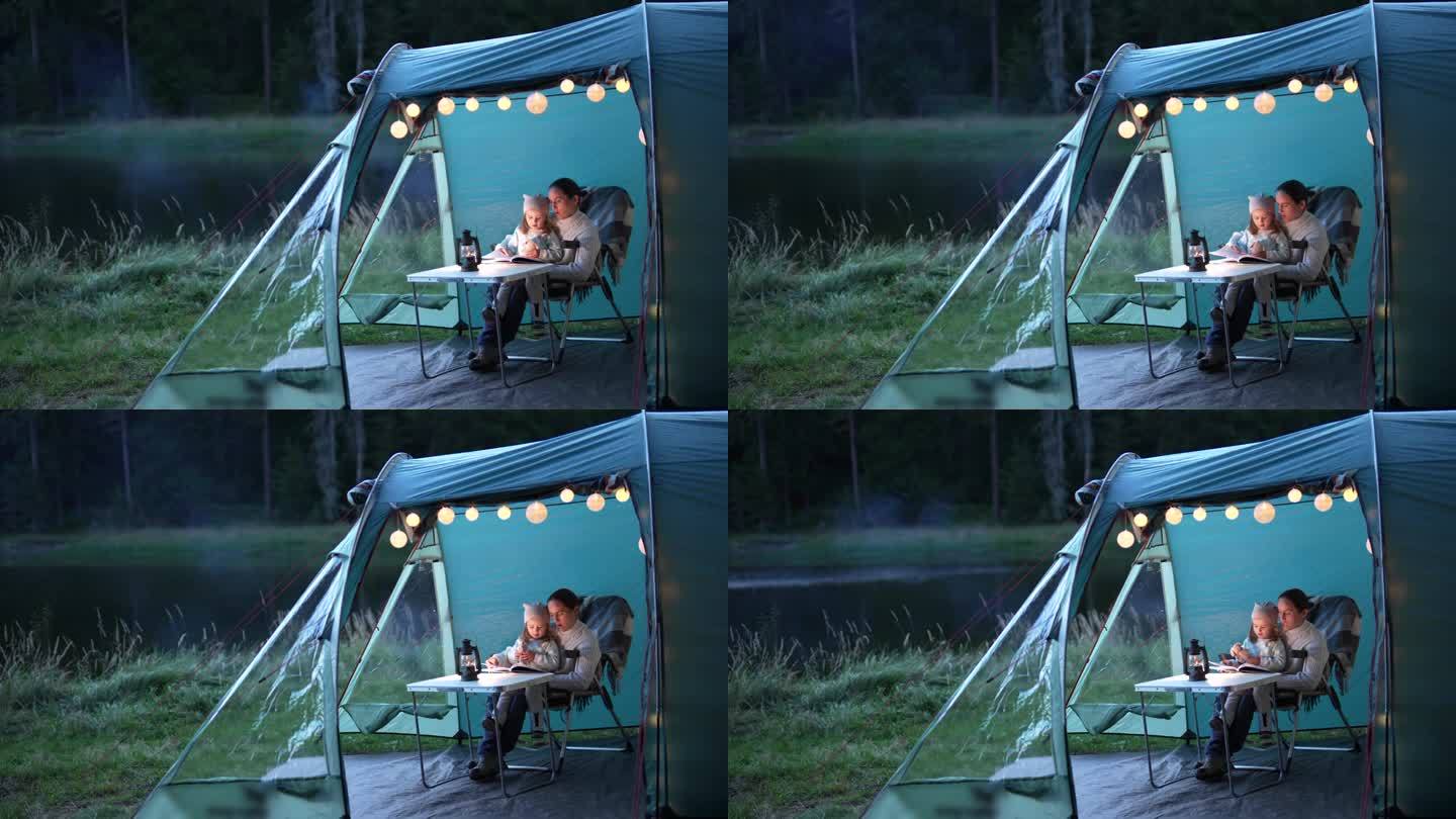一家人在湖边露营。和妈妈在帐篷里讲睡前故事。