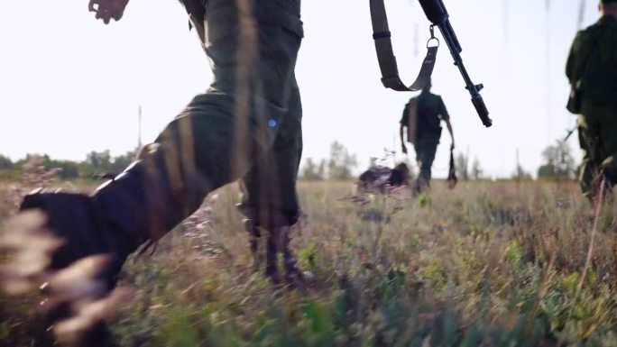 一队武装士兵带着服务犬在边境巡逻，特种安全部队