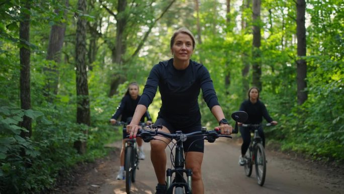 一群女性在大自然中骑自行车，女性朋友或姐妹一起在森林里骑自行车