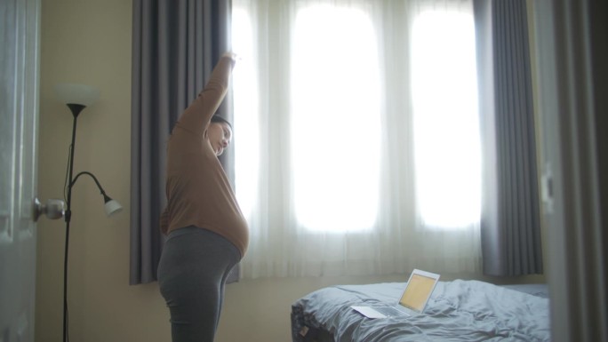 亚洲孕妇在卧室里做瑜伽
