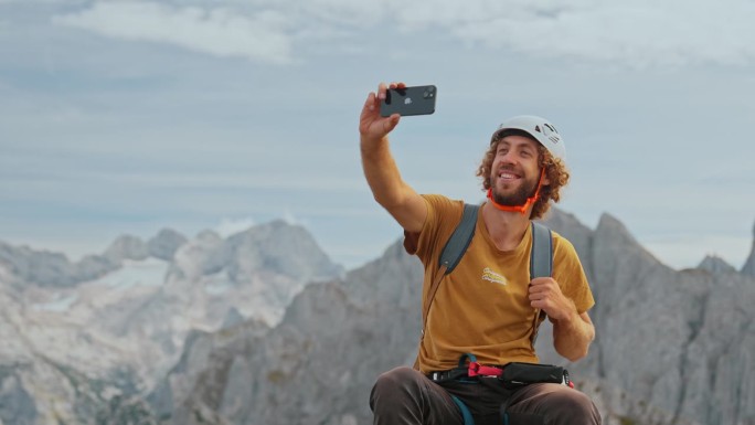 一名男子在登山后在山顶上使用智能手机