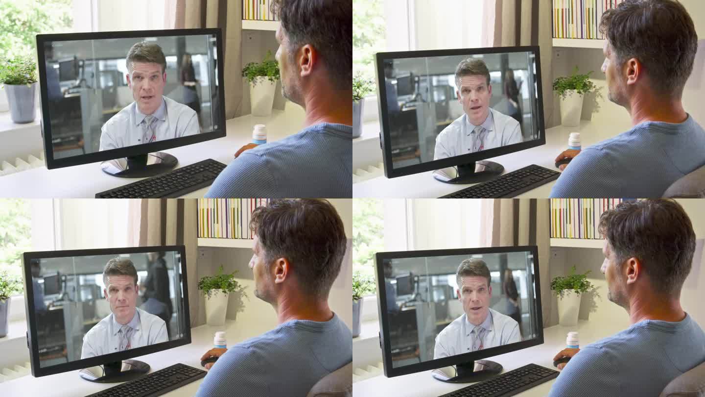 一个人坐在电脑旁，通过视频电话和他的医生交谈
