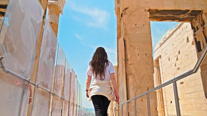 年轻女子参观希腊雅典卫城的历史地标。