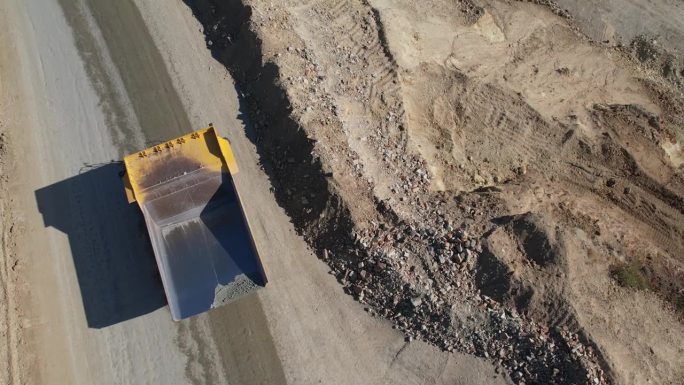 驾驶自卸车运输金矿坑开挖采石场挖出的矿石，慢镜头