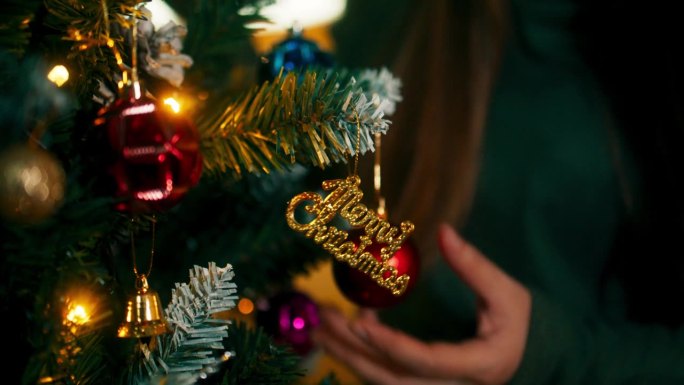 人们在客厅里用彩球、铃铛和礼盒装饰圣诞树，准备圣诞活动