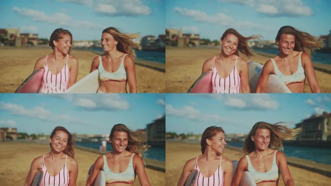 快乐的女性冲浪朋友们在阳光明媚的海滩上带着冲浪板散步