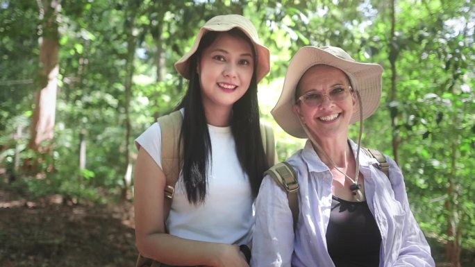 徒步旅行者有吸引力的快乐的年轻女孩背着背包在山上徒步旅行，周围都是令人惊叹的风景