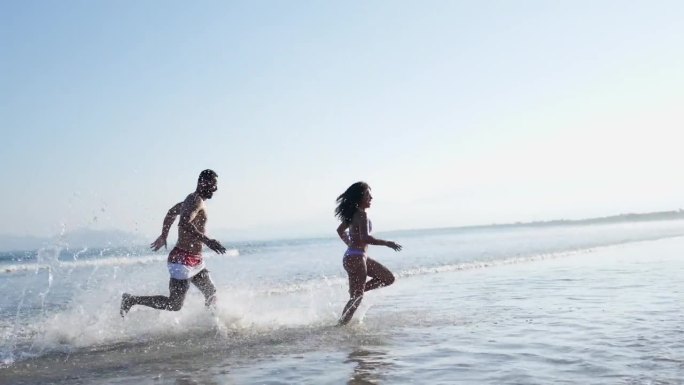父亲和女儿在海滩上玩海的时候玩得很开心